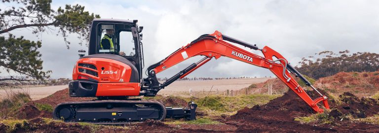 Orange excavator completing civil trenching works