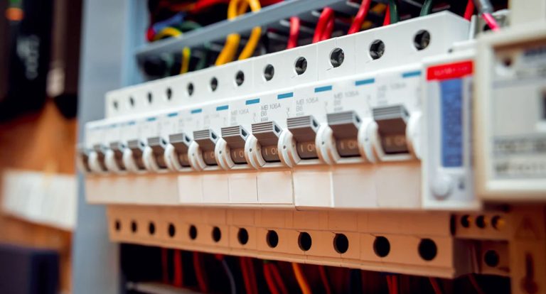 Close-up of a residential electrical breaker panel with multiple circuit breakers and colored wires. (Informative)